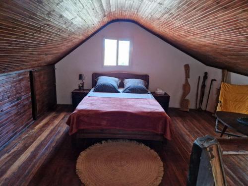 a bedroom with a large bed in a attic at la Maison rouge in Toliara