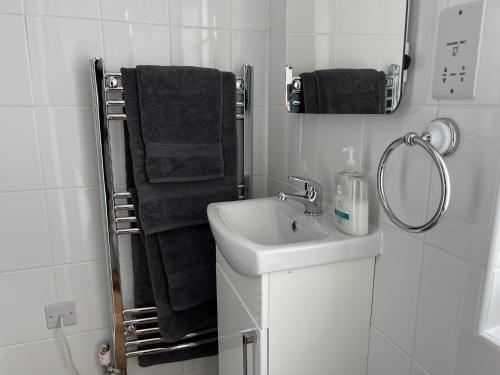 a white bathroom with a sink and a mirror at Glastonbury Town Centre - Large 2 Bedroom Apt With Balcony in Glastonbury