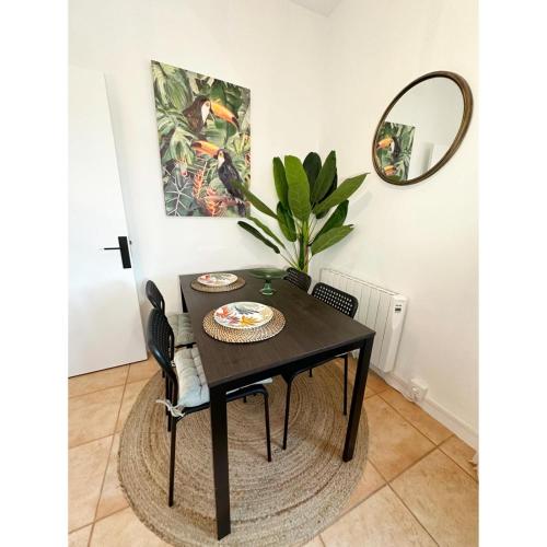 a black dining room table with chairs and a mirror at La Nueva Casa del Barco del Humo in Vigo