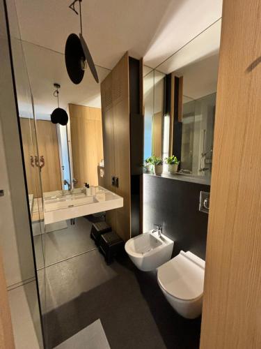 a bathroom with two toilets and a sink and a mirror at Altoria Active Gdynia in Gdynia