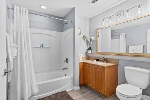 a bathroom with a tub and a toilet and a sink at Scenic View Condo Near Disney in Orlando