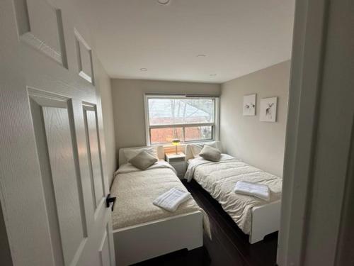 a small room with two beds and a window at Enjoy luxury living in Mississauga