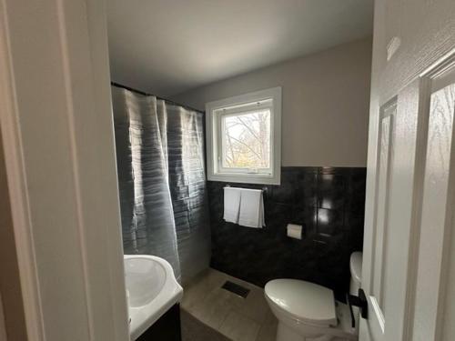 a bathroom with a sink and a toilet and a window at Enjoy luxury living in Mississauga
