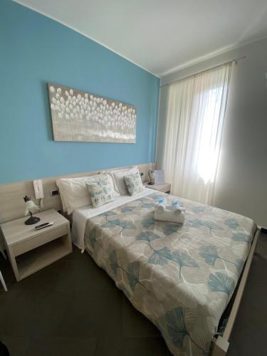 a bedroom with a large bed and a blue wall at Pensione Sorriso in Vernazza
