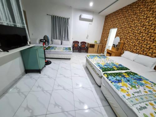 a room with two beds and a flat screen tv at Mai Thảo in Vung Tau