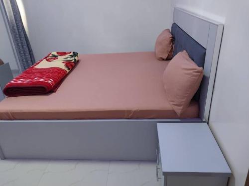 a small bed with a red blanket on it at Space home in Dakar