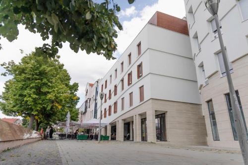 a white building on the side of a street at Fontana apartmani 1 FREE parking in Tuzla