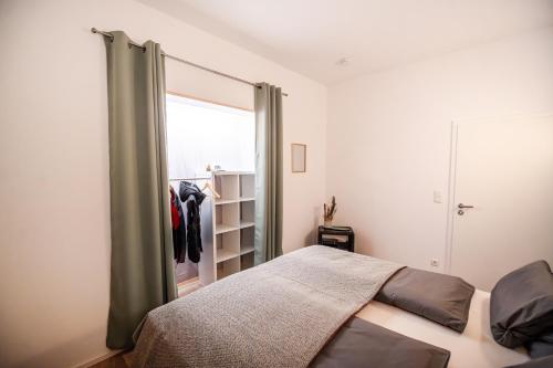 1 dormitorio con cama y armario con ventana en Landhaus Oase im Herzen Oberviechtachs, en Oberviechtach