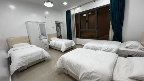 1 Schlafzimmer mit 3 Betten und einem Spiegel in der Unterkunft استراحة روضة الوادي in Nizwa