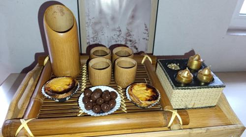 a wooden table with muffins and desserts on it at Orion Guesthouse Telhado in Fundão