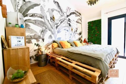 - une chambre avec un lit sur un cadre en bois dans l'établissement Villa Gisèla, à Saint-Mandrier-sur-Mer