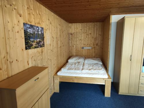 a small bedroom with a bed in a wooden room at Kleine Freiheit Nummer 5 in Reichendorf