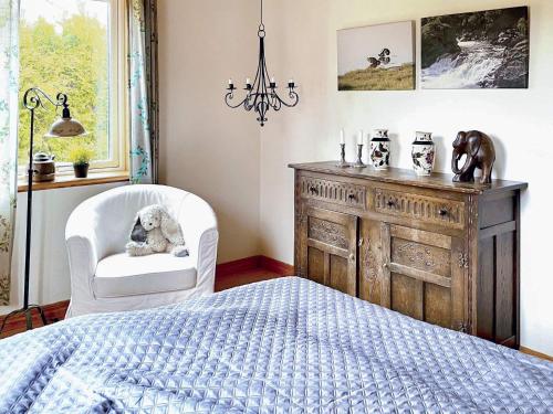 a bedroom with a bed and a chair and a dresser at Holiday home ONSALA VI in Onsala