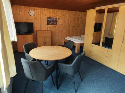 a room with a wooden table and chairs and a bed at Kleine Freiheit Nummer 5 in Reichendorf