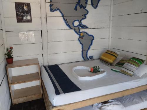 Cama en habitación con mapa del mundo en Hostel Ichtus, en Playa Blanca