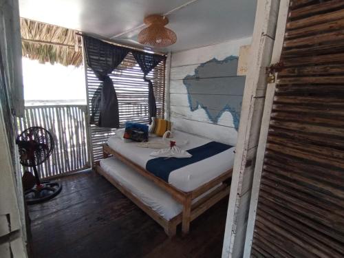 1 dormitorio con 1 cama en una habitación con ventana en Hostel Ichtus, en Playa Blanca