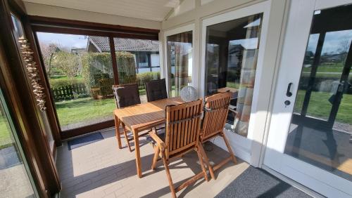 a porch with a wooden table and a wooden bench at Ferienhaus Namenlos in Butjadingen