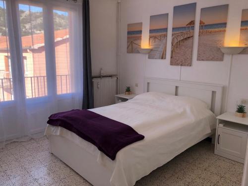 une chambre avec un grand lit blanc et une fenêtre dans l'établissement T3 VALLESPIR AMELIE LES BAINS, à Amélie-les-Bains-Palalda