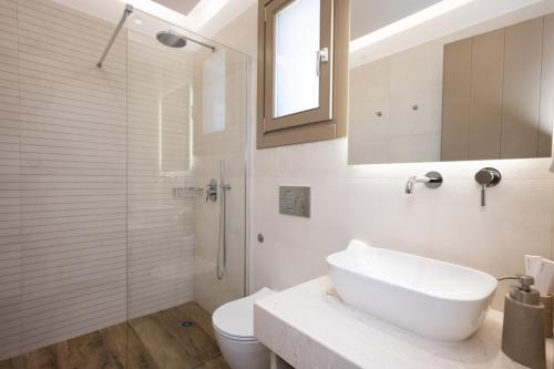 e bagno con lavandino, servizi igienici e doccia. di Maistros Apartments Mykonos a Ftelia