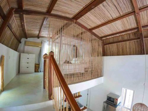 a large room with a wooden ceiling and a staircase at Sanjana & Julien's in Tamarin