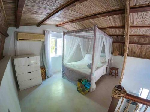 ein Schlafzimmer mit einem Himmelbett in einem Zimmer in der Unterkunft Sanjana & Julien's in Tamarin