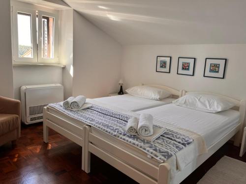 sypialnia z białym łóżkiem i ręcznikami w obiekcie Apartman Oscar Mali Lošinj w miejscowości Mali Lošinj