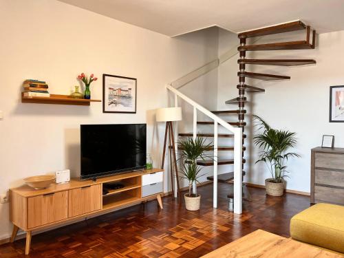 a living room with a tv and a staircase at Apartment Oscar in Mali Lošinj