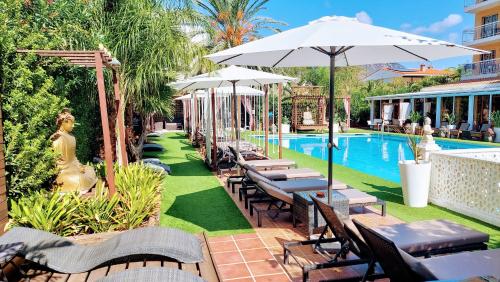 a resort with a pool with tables and umbrellas at Montreal in Benicàssim