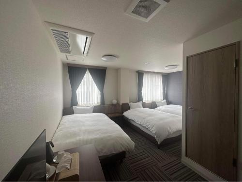 Postel nebo postele na pokoji v ubytování WORLD ASAHI HOTEL