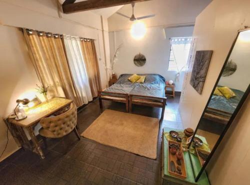 a bedroom with a bed and a table and a mirror at The Patnem villa in Canacona