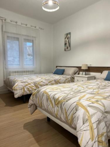 a bedroom with two beds and a window at VuT El Refugio de Santiago in Ávila