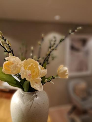 a white vase with yellow flowers in it at Hotell Rådhuset in Lidköping