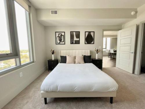 a bedroom with a large white bed with two windows at The Perfect Scenario in Buckhead in Atlanta