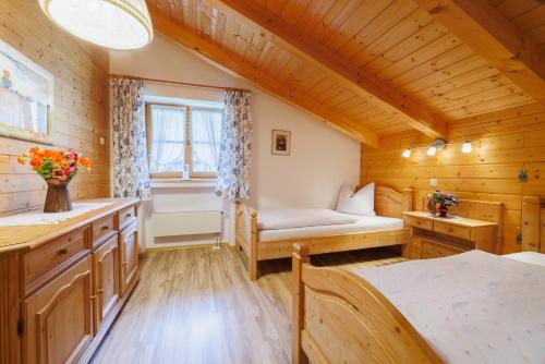 ein Schlafzimmer in einem Blockhaus mit einem Bett und einem Fenster in der Unterkunft Ferienwohnung Klöpping in Ruhpolding