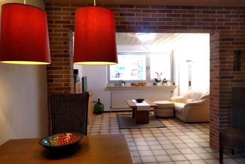 uma sala de estar com duas luzes vermelhas e uma mesa em NiBo Hof - Ruhig und verkehrsgünstig em Goch