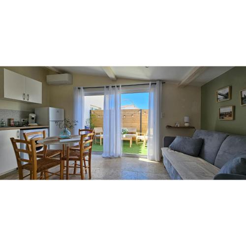 un salon avec un canapé et une table avec des chaises dans l'établissement Chez Lisa, à Port-Saint-Louis-du-Rhône