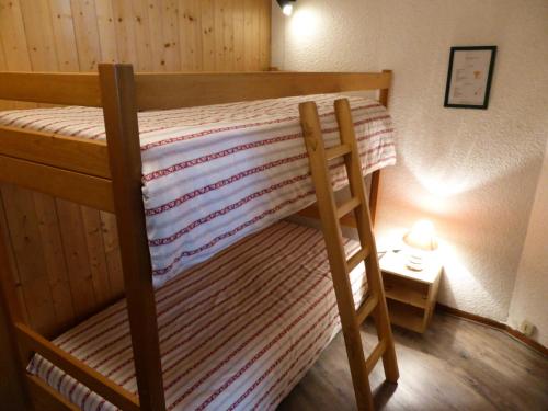ein Etagenbett mit einer gestreiften Decke darüber in der Unterkunft Résidence Le Brulaz - Studio pour 5 Personnes 47 in Les Contamines-Montjoie