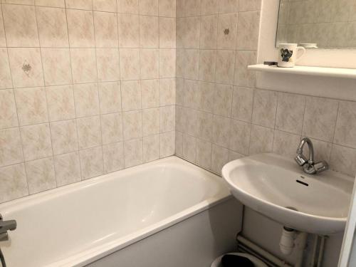 une salle de bain avec une baignoire blanche et un lavabo dans l'établissement Résidence L'enclave - Enclave I638 MAE-5354, aux Contamines-Montjoie