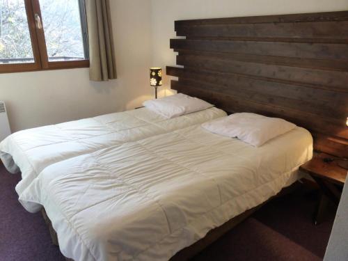 - une chambre avec 2 lits et une tête de lit en bois dans l'établissement Résidence Les Fermes De Saint Gervais - Fermes de Saint Gervais B25 MAE-5221, à Saint-Gervais-les-Bains