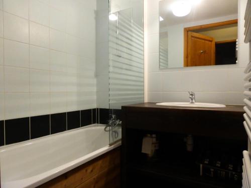 une salle de bain avec une baignoire, un lavabo et un miroir dans l'établissement Résidence Les Fermes De Saint Gervais - Fermes de Saint Gervais B25 MAE-5221, à Saint-Gervais-les-Bains
