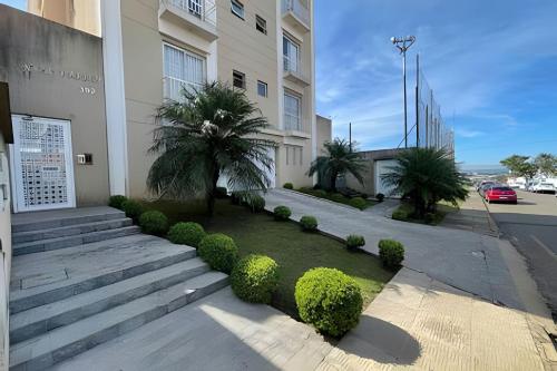 um edifício com escadas e arbustos ao lado de uma rua em Apartamento 2 quartos c/ garagem em Ponta Grossa