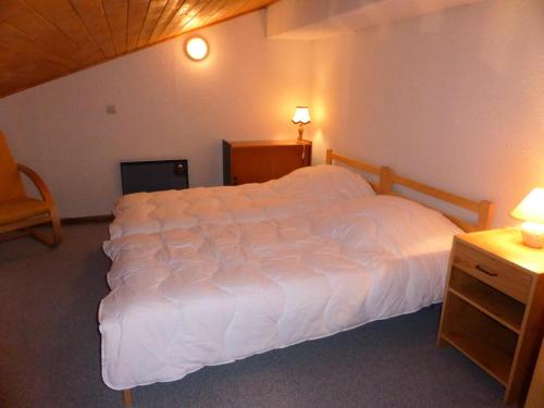 une chambre avec un grand lit blanc dans une pièce dans l'établissement Résidence Schuss - Schuss B230 MAE-5335, aux Contamines-Montjoie