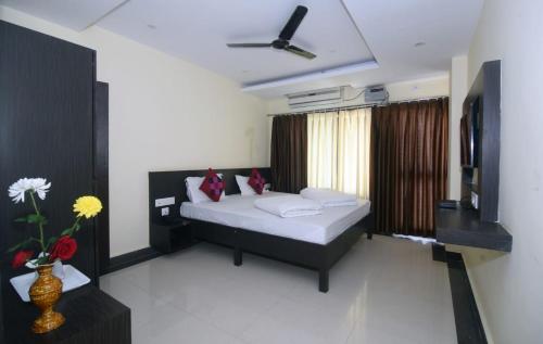 a bedroom with a bed and a television in it at Hotel Light House INN in Puri