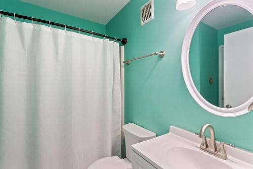 a bathroom with a white toilet and a mirror at SC2C Sands Shamrock Oceanfront in Kill Devil Hills