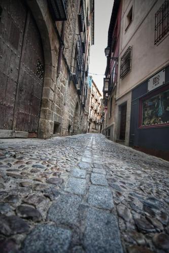 an empty cobblestone street in an alley with buildings at La Madriguera de Toledo in Bargas