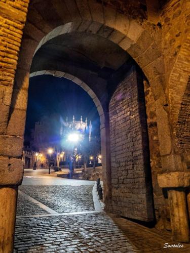 an archway with a view of the castle at night at La Madriguera de Toledo in Bargas