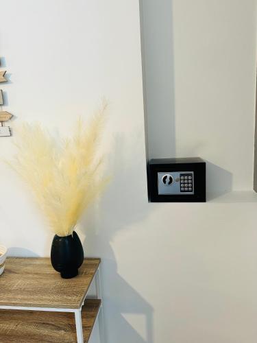 a black vase sitting on a table with a clock at Chez romain in Massiac
