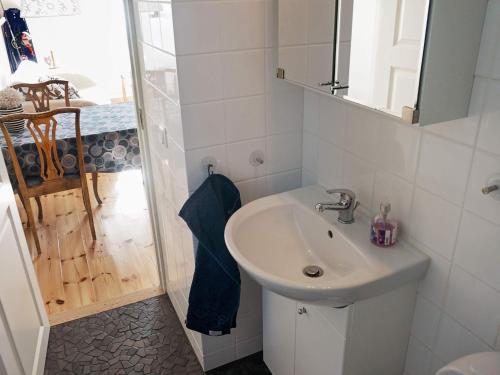 a white bathroom with a sink and a shower at Holiday home FäRENTUNA in Kungsberga