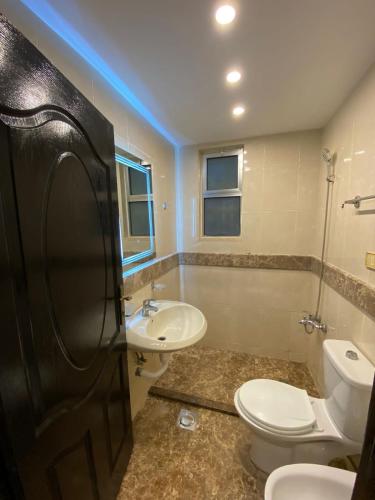 a bathroom with a toilet and a sink at San Vito Luxury apartment in Sowayma
