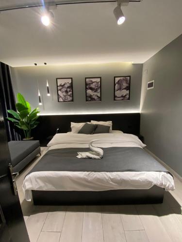 San Vito Luxury apartment في السويمة: غرفة نوم بسرير كبير عليها ثعبان أبيض